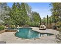 This gorgeous in-ground pool features custom stonework and lush landscaping at 113 Regents Sq, Peachtree City, GA 30269