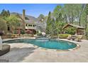 The backyard has a luxurious pool, lounge chairs, and a covered outdoor seating area at 113 Regents Sq, Peachtree City, GA 30269