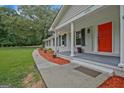 Close-up of a home's front porch with white columns, a red door, and freshly laid mulch at 3290 Ebenezer Se Rd, Conyers, GA 30094