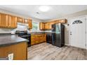 Classic kitchen features wood cabinets, dark countertops, and a modern black refrigerator at 5724 Amalfi Way, Douglasville, GA 30135