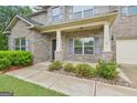 Inviting front porch features brick columns and lush landscaping for a welcoming entry at 12323 Styron Dr, Hampton, GA 30228