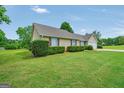 Well-maintained single-story home with a manicured lawn, trimmed hedges, and side-entry garage at 130 Belmont Trl, Covington, GA 30016