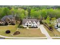 Aerial view of an elegant home with a manicured lawn and mature trees in a serene setting at 157 Waterlace Way, Fayetteville, GA 30215