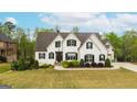 Beautiful white home with black shutters, a lush lawn, and mature trees at 157 Waterlace Way, Fayetteville, GA 30215