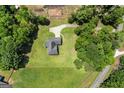 Aerial view of brick home with circular driveway nestled amongst lush greenery, offering privacy and curb appeal at 3950 Chattahoochee Rd, Cumming, GA 30041