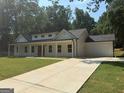 A single-Gathering home showcasing a long driveway and a charming covered porch at 5431 S Lake Dr, Douglasville, GA 30135