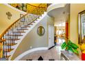 Inviting foyer with elegant staircase, decorative iron railings and marble tile flooring at 1214 Greenridge Ln, Lithonia, GA 30058