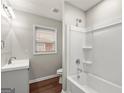 Bright bathroom featuring a shower-tub combination with white tile surround and a single sink vanity at 1030 Westmoor Nw Dr, Atlanta, GA 30314