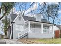 Angle view of the grey brick home highlighting the covered porch and stairs leading to the front door at 1030 Westmoor Nw Dr, Atlanta, GA 30314