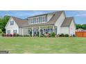 Beautiful two-story home with a wide front porch, blue shutters, and meticulously maintained landscaping at 17 Sawtooth Oak Dr, Moreland, GA 30259