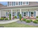 Inviting front porch featuring elegant hanging lanterns, potted plants, and comfortable seating at 17 Sawtooth Oak Dr, Moreland, GA 30259