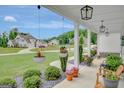 Covered porch view showcasing hanging flower baskets, well-manicured landscaping, and neighborhood scenery at 17 Sawtooth Oak Dr, Moreland, GA 30259