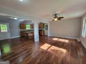 Open-concept living area featuring hardwood floors, a ceiling fan, and easy access to the kitchen and a door to the exterior at 7290 Grayson Dr, Riverdale, GA 30296