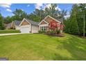 Charming home featuring a lush green lawn, beautiful landscaping, and a two-car garage at 9178 Lakeview Pkwy, Villa Rica, GA 30180