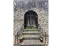 Arched front entrance and decorative iron gate of a charming brick house at 2219 Riverbrook Rd, Decatur, GA 30035