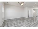 Spacious living room with stylish gray flooring, natural light, and a ceiling fan at 455 Prescott Way, Villa Rica, GA 30180