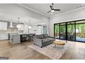 Bright living room with a gray sofa, open floor plan, leading to the kitchen and a view of the outdoor deck at 180 Lapis Lake Pt, Fayetteville, GA 30215