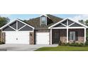 Charming single-story home with brick and siding, featuring a three-car garage and well-manicured lawn at 100 Grande Bishop Dr, Fairburn, GA 30213