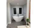Elegant bathroom featuring a standalone tub and stylish leaded glass windows at 2321 Norbury Se Cv, Smyrna, GA 30080