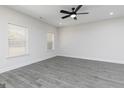Bright bedroom with gray wood floors, two windows, and a ceiling fan at 677 Cantrell Drive, Dallas, GA 30157