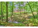 View of the home nestled among mature trees with a charming front porch at 305 Postwood Dr, Fayetteville, GA 30215