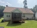 Lovely back exterior featuring a screened-in porch and a well-manicured green lawn for outdoor enjoyment and relaxation at 650 Flippen Rd, Stockbridge, GA 30281