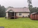 The back exterior with a screened porch and a utility shed sits on a lush green lawn at 650 Flippen Rd, Stockbridge, GA 30281