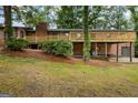 Home with a large wooden deck, brick facade, and a well-maintained lawn at 1124 Ponderosa Park Dr, Forest Park, GA 30297