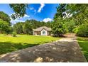 Scenic property featuring a long driveway, lush greenery, and beautiful landscaping at 130 Laurel Lake Rd, Tyrone, GA 30290