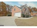 Charming home featuring a spacious driveway leading to an attached garage and manicured landscaping at 355 Woodbyne Dr, Fayetteville, GA 30214
