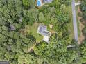 An aerial view showcases a private residence nestled amongst lush, mature trees at 25 Highlands Way, Oxford, GA 30054