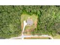 Aerial view of a wooded lot with a house, long driveway, and a private backyard at 74 Riverwood Trl, Grantville, GA 30220