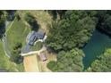 This aerial view features the home's layout, horse arena, nearby pond, and surrounding woods at 135 Brookshire Dr, Fayetteville, GA 30215