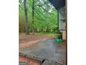 Image shows a section of the backyard with trees, bamboo, and a small concrete patio area at 106 Garden Trl, Stockbridge, GA 30281