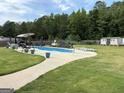 Large backyard with in-ground pool, shed, swing set, lounge chairs, and manicured green grass at 175 Bridgemill Dr, Covington, GA 30014