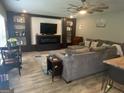 Cozy living room featuring a large sectional sofa, decorative ceiling fan, and custom built-ins at 175 Bridgemill Dr, Covington, GA 30014