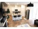 Open-concept kitchen with white cabinets, stainless steel appliances, and an island with barstool seating at 2845 Long Shadow Ct, Snellville, GA 30078