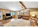 Open living room featuring hardwood floors, ceiling fan, and comfortable leather furniture at 9706 Holly Hill Way, Jonesboro, GA 30238