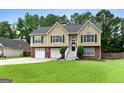 Inviting home featuring a well-kept lawn, tidy landscaping, and a welcoming front entrance at 341 Jodeco Station E Cir, Stockbridge, GA 30281