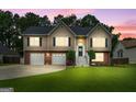 Beautiful home exterior showcasing manicured lawn, warm lighting, and a welcoming facade at dusk at 341 Jodeco Station E Cir, Stockbridge, GA 30281