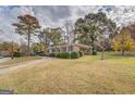 Well-maintained brick home with mature trees, a spacious front yard, and a convenient carport at 7111 Indian Creek Sw Cir, Covington, GA 30014