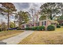Attractive brick home with a long driveway and carport, surrounded by well-manicured landscaping at 7111 Indian Creek Sw Cir, Covington, GA 30014