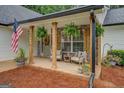 Inviting front porch with stone columns and a cozy seating area for relaxing at 160 Laurel Ln, Social Circle, GA 30025