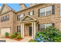 Inviting brick home entrance with a covered porch, black front door, and colorful landscaping at 412 Culloden Moor, Mcdongough, GA 30253