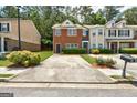 Brick townhouse showcasing a front yard with manicured landscaping and private parking space at 4862 Park Cir, Atlanta, GA 30349