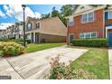 View of the townhouse with a private driveway surrounded by green lawn and mature landscaping at 4862 Park Cir, Atlanta, GA 30349