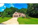 Well-maintained brick house with a two-car garage and beautiful landscaping surrounded by mature trees at 6830 Peeksville Rd, Mcdonough, GA 30252