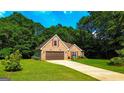 Inviting brick home with attached garage, complemented by lush greenery, and a well-kept lawn at 6830 Peeksville Rd, Mcdonough, GA 30252