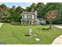 Charming two-story home featuring a well-manicured lawn and classic green shutters at 1600 Coal Shovel Ne Trl, Conyers, GA 30013