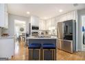 Bright kitchen with white cabinets, stainless appliances, granite counters and an island with bar stool seating at 345 Kerrith Dr, Stockbridge, GA 30281